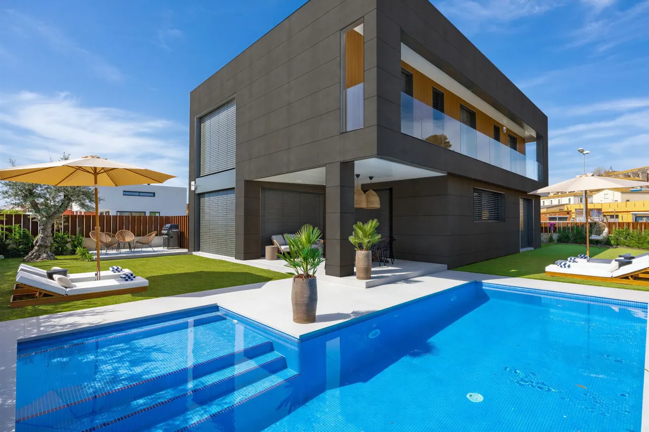 La misma vivienda con la fachada revestida con paneles de gran formato.