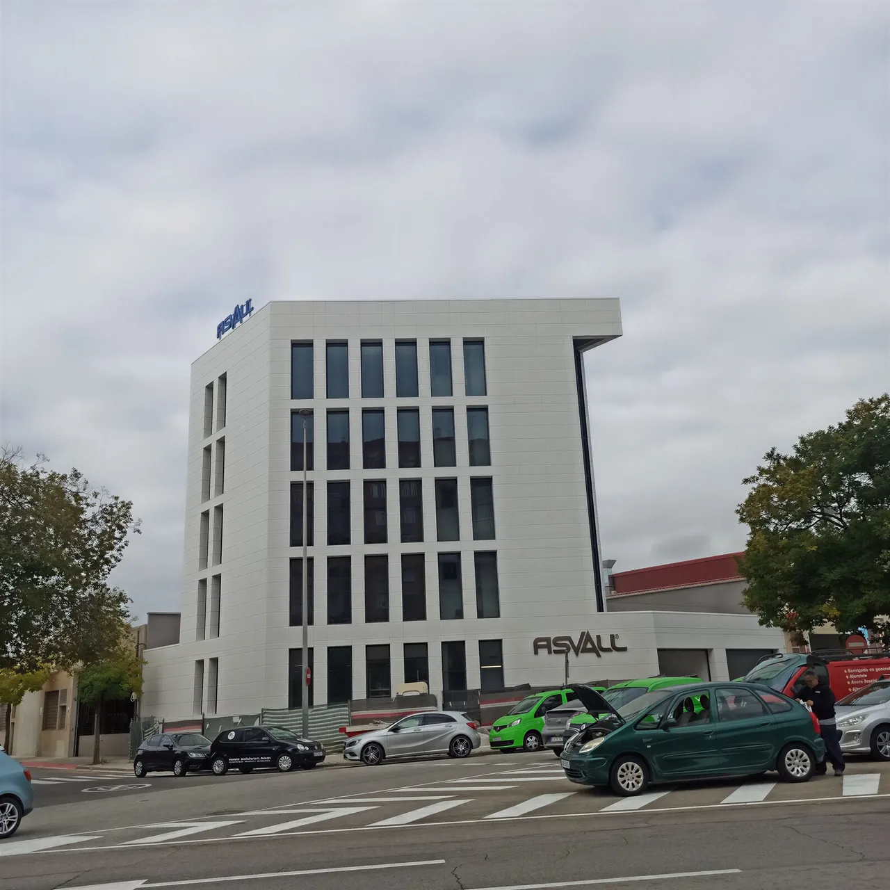 Edificio de oficinas de cinco plantas con fachada blanca de piezas rectangulares y huecos verticales.
